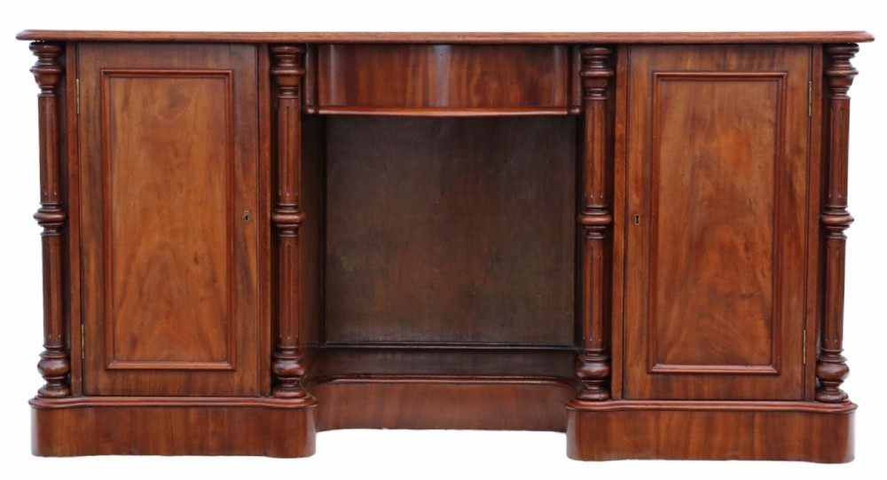 A 19th-century mahogany twin pedestal writing desk featuring a gold-tooled leather inset top, twin cupboard doors flanked by turned columns, and a central kneehole. View II