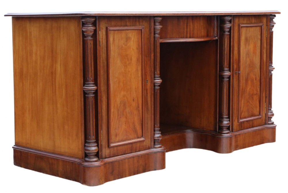 A 19th-century mahogany twin pedestal writing desk featuring a gold-tooled leather inset top, twin cupboard doors flanked by turned columns, and a central kneehole. View VIII