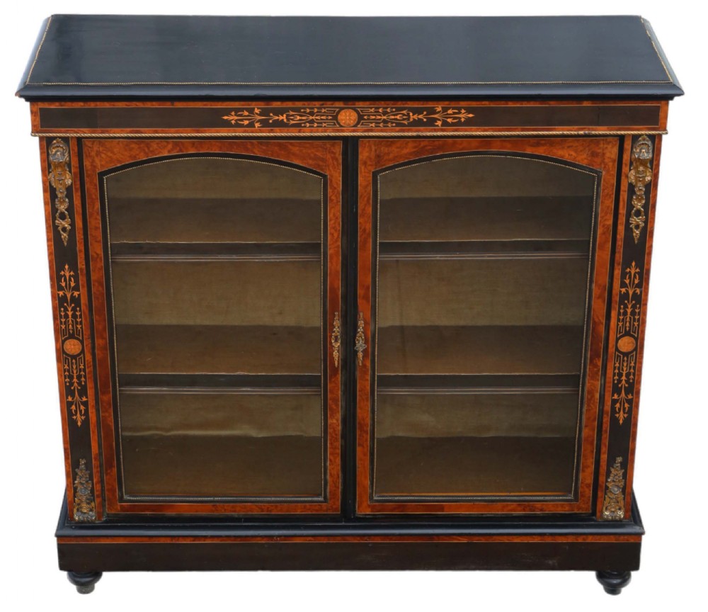 A late 19th-century Aesthetic Movement ebonised and burr walnut pier display cabinet with twin glazed doors and marquetry inlay.