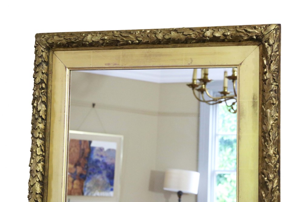 A large 19th-century rectangular wall mirror featuring a gilded frame with a carved leaf outer border and flat inner profile. View IV