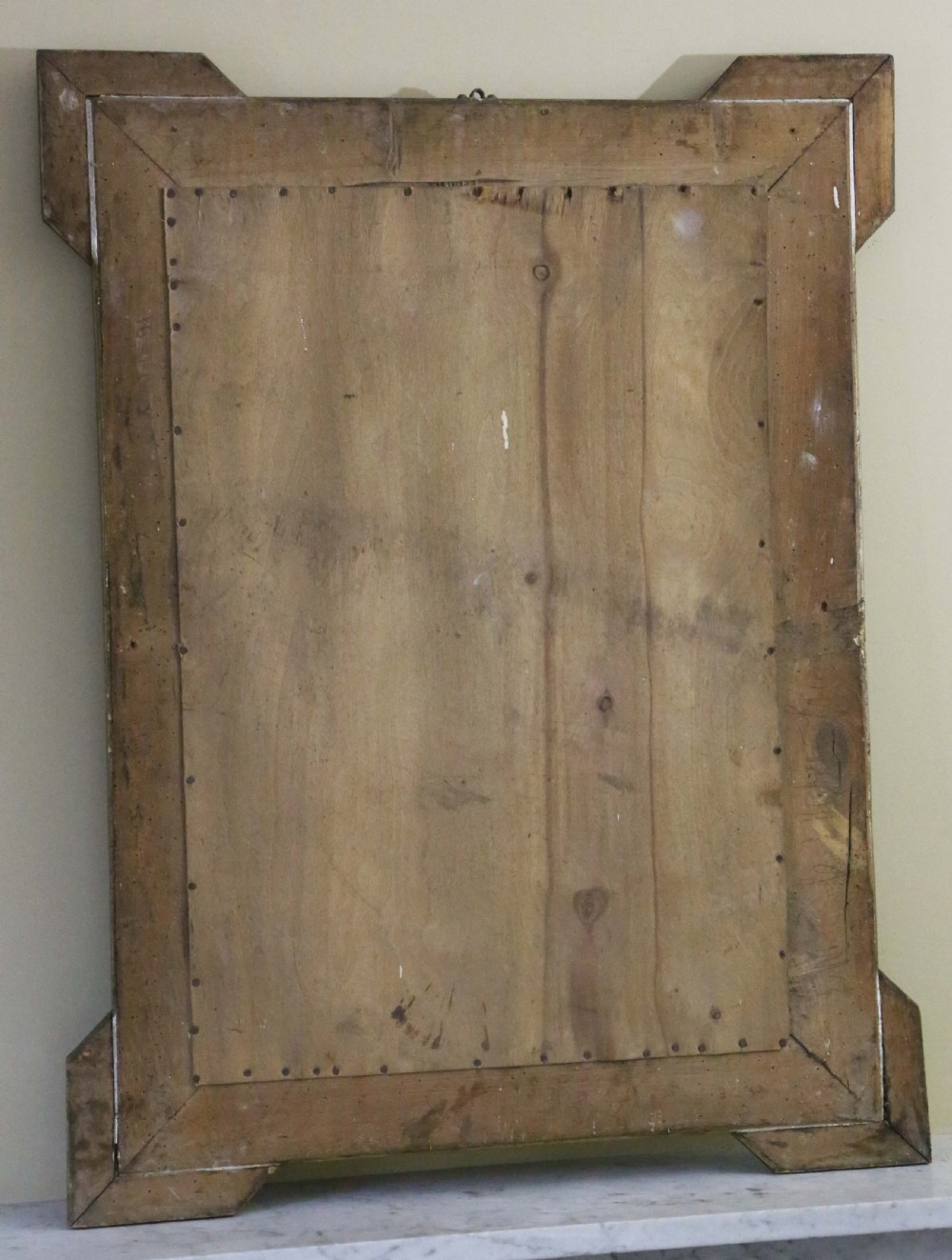 An antique rectangular gilt wall mirror featuring ornate foliate mouldings, projecting corner ears, and a beaded inner border. View VI