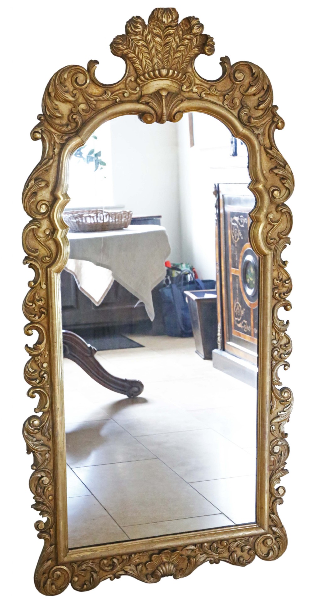 A tall Rococo Revival giltwood overmantel wall mirror featuring an arched top crested with carved plume motifs and surrounded by scrolling foliage.