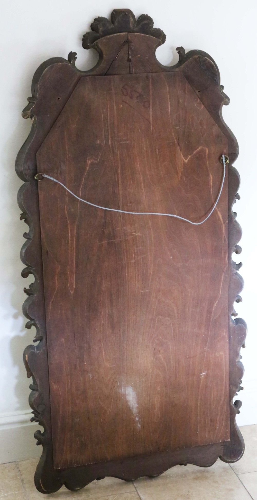A tall Rococo Revival giltwood overmantel wall mirror featuring an arched top crested with carved plume motifs and surrounded by scrolling foliage. View III