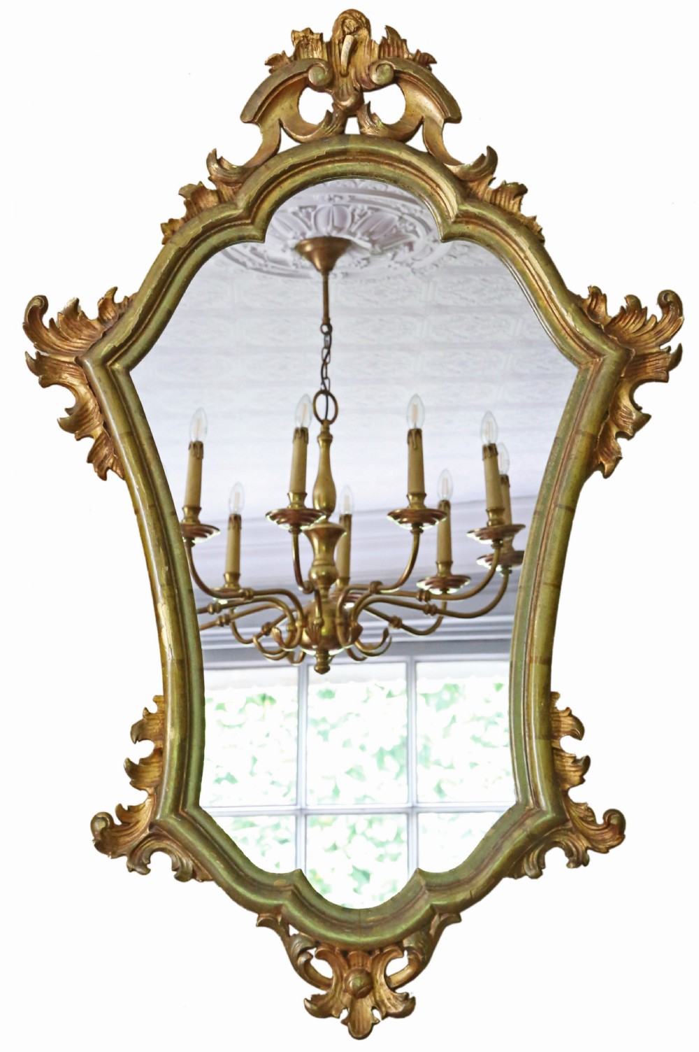 An ornate turn-of-the-century Rococo Revival overmantel mirror featuring a carved gilt wood frame with fluid scrollwork and foliage cresting.