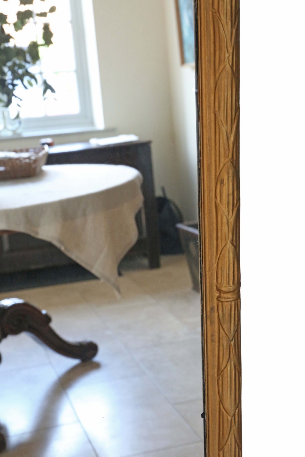 A tall rectangular full-length mirror featuring a gilded wood frame topped with a bow and ribbon cresting. View IV