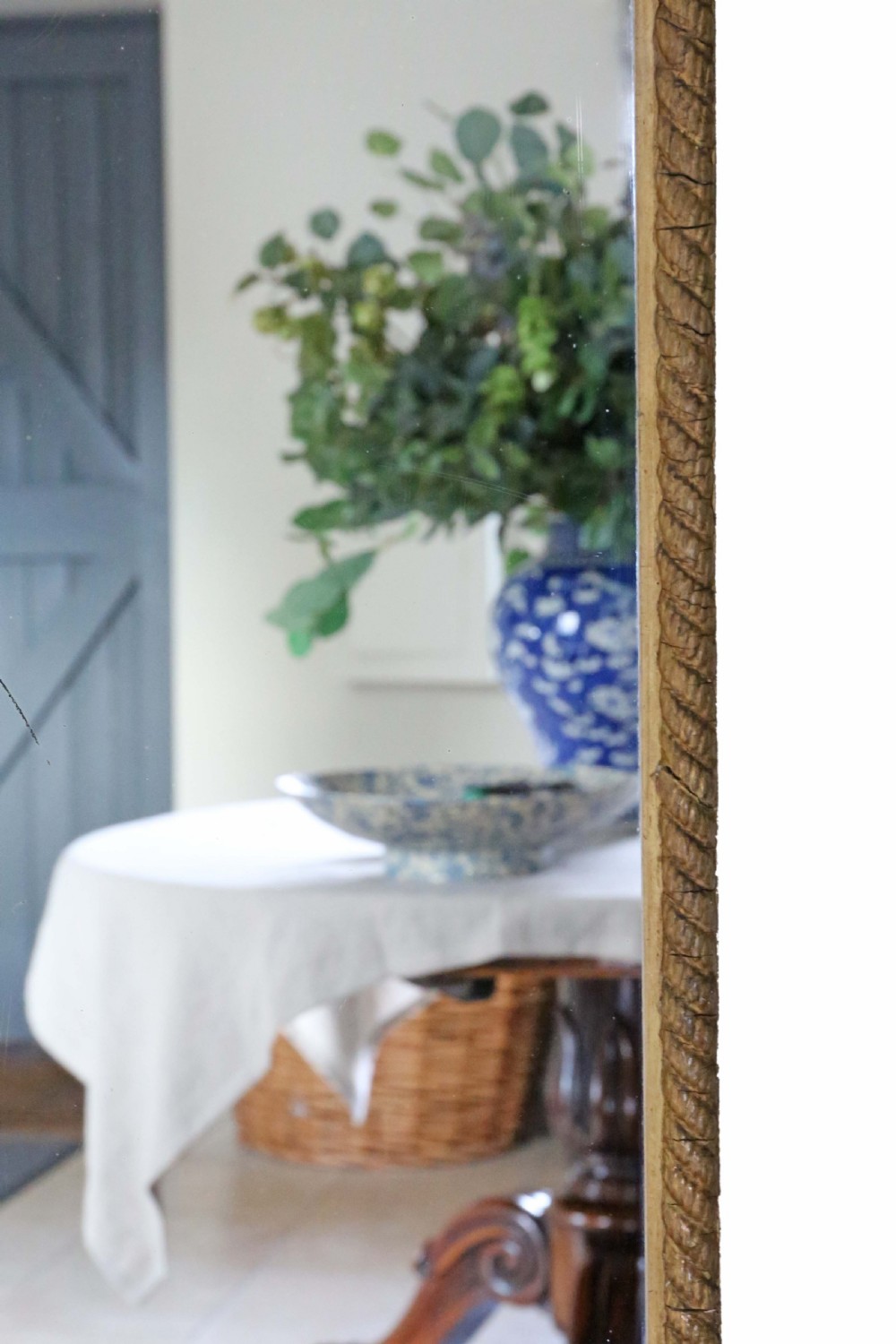 A tall Edwardian full-length mirror featuring a gold leaf rope-twist frame and an ornate looped crest at the top. View V