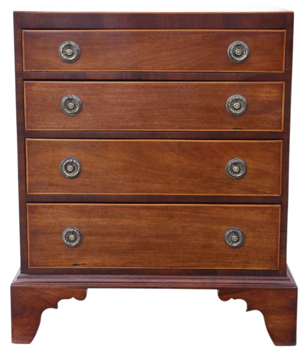 A Georgian Revival mahogany chest of drawers with four graduated drawers, brass ring handles, boxwood inlay, and bracket feet.