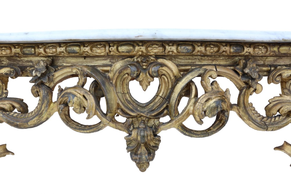 A 19th-century Rococo style giltwood console table featuring a contoured white marble top and a heavily carved pierced apron on curved legs. View VIII