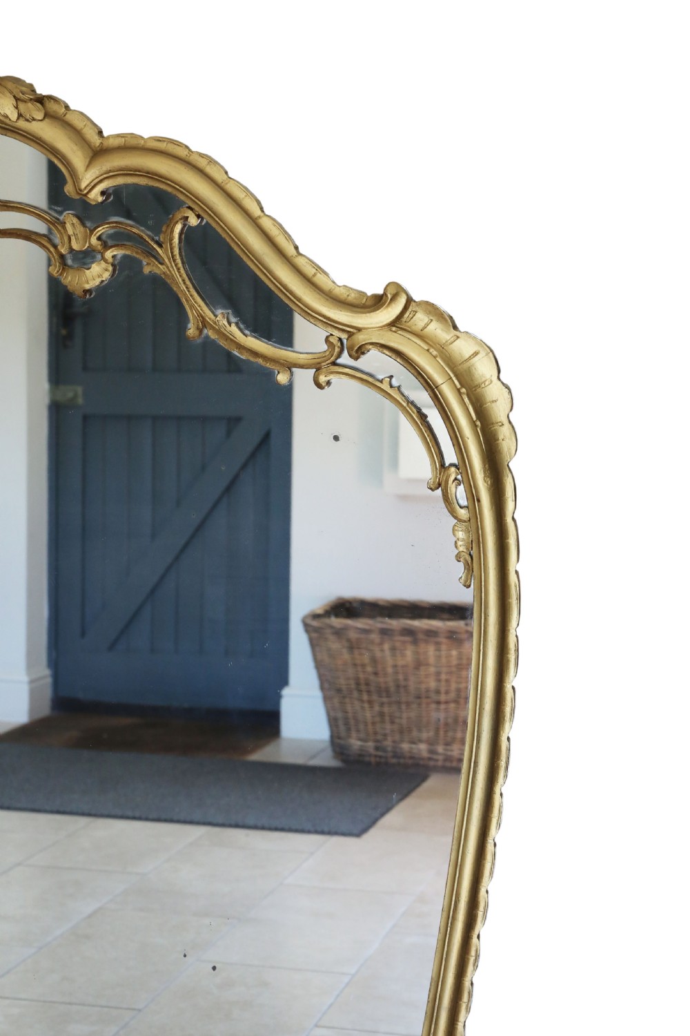 A large Rococo Revival giltwood overmantel wall mirror featuring an ornate carved shell crest, scrolling openwork accents, and a gold leaf finish. View VI