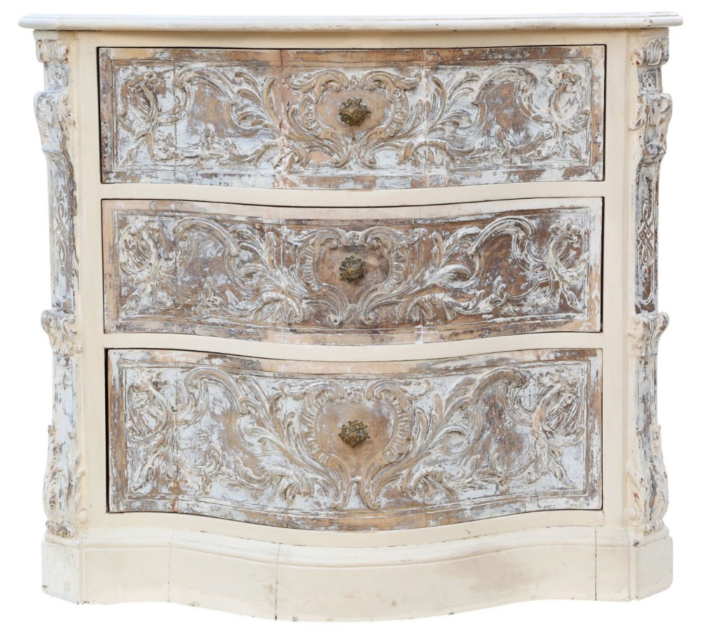 A cream-painted Italian serpentine chest of drawers featuring three carved drawer fronts and distressed paint finish.