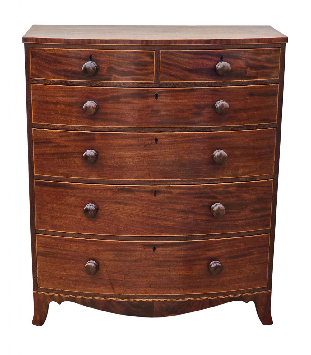 A nineteenth century mahogany bow front chest of drawers with two short over three long graduated drawers, featuring turned timber handles and delicate boxwood stringing.