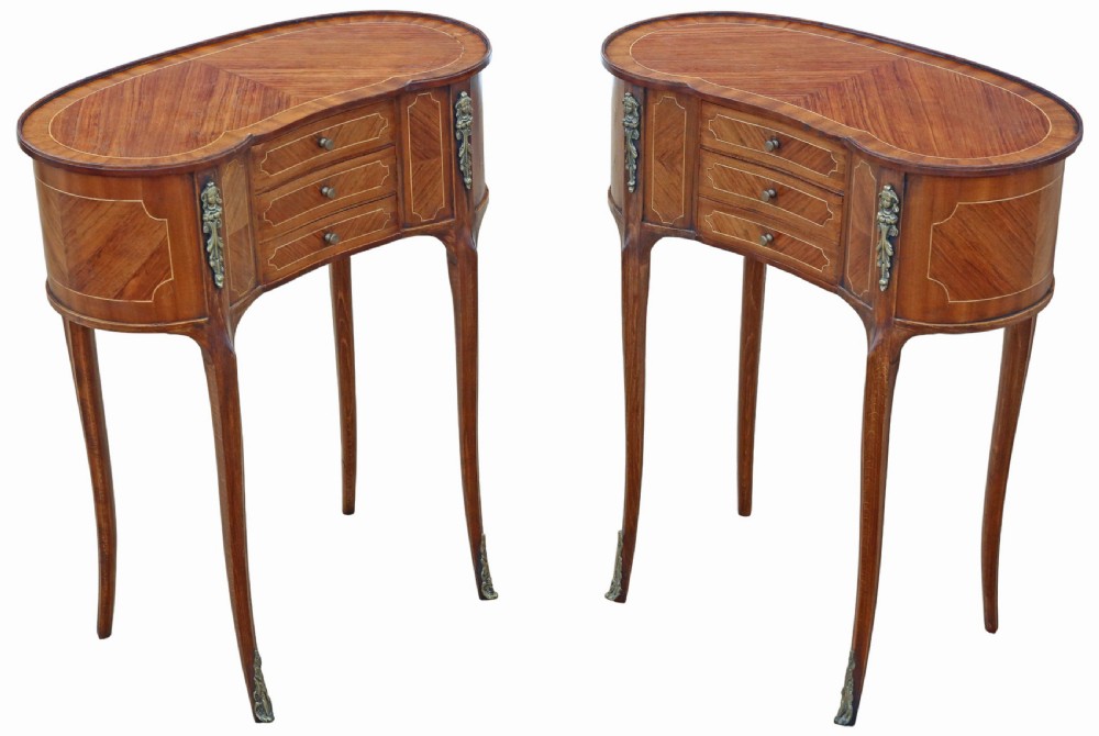 A pair of matching 1920s kidney-shaped timber bedside tables featuring inlaid veneering, central drawers, cabriole legs, and metal knee mounts. View V