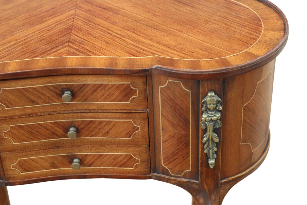 A pair of matching 1920s kidney-shaped timber bedside tables featuring inlaid veneering, central drawers, cabriole legs, and metal knee mounts. View X