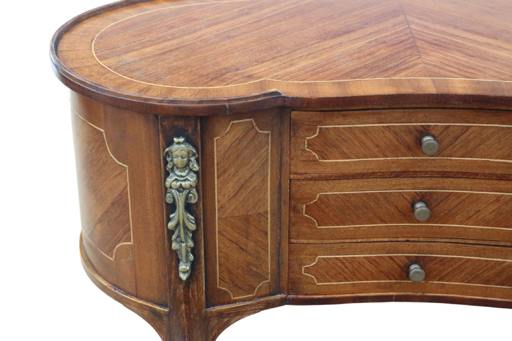 A pair of matching 1920s kidney-shaped timber bedside tables featuring inlaid veneering, central drawers, cabriole legs, and metal knee mounts. View XI