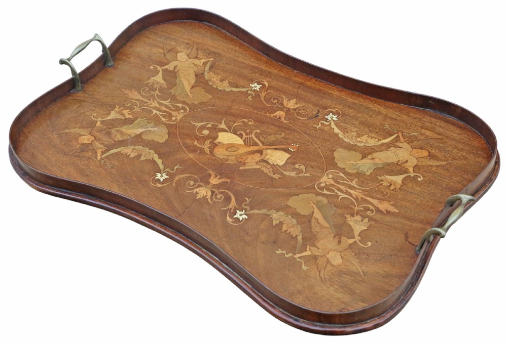An Edwardian shaped mahogany serving tray featuring intricate marquetry inlay of cherubs and musical instruments with two brass handles.