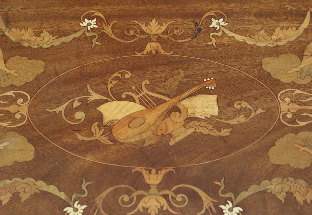 An Edwardian shaped mahogany serving tray featuring intricate marquetry inlay of cherubs and musical instruments with two brass handles. View VI