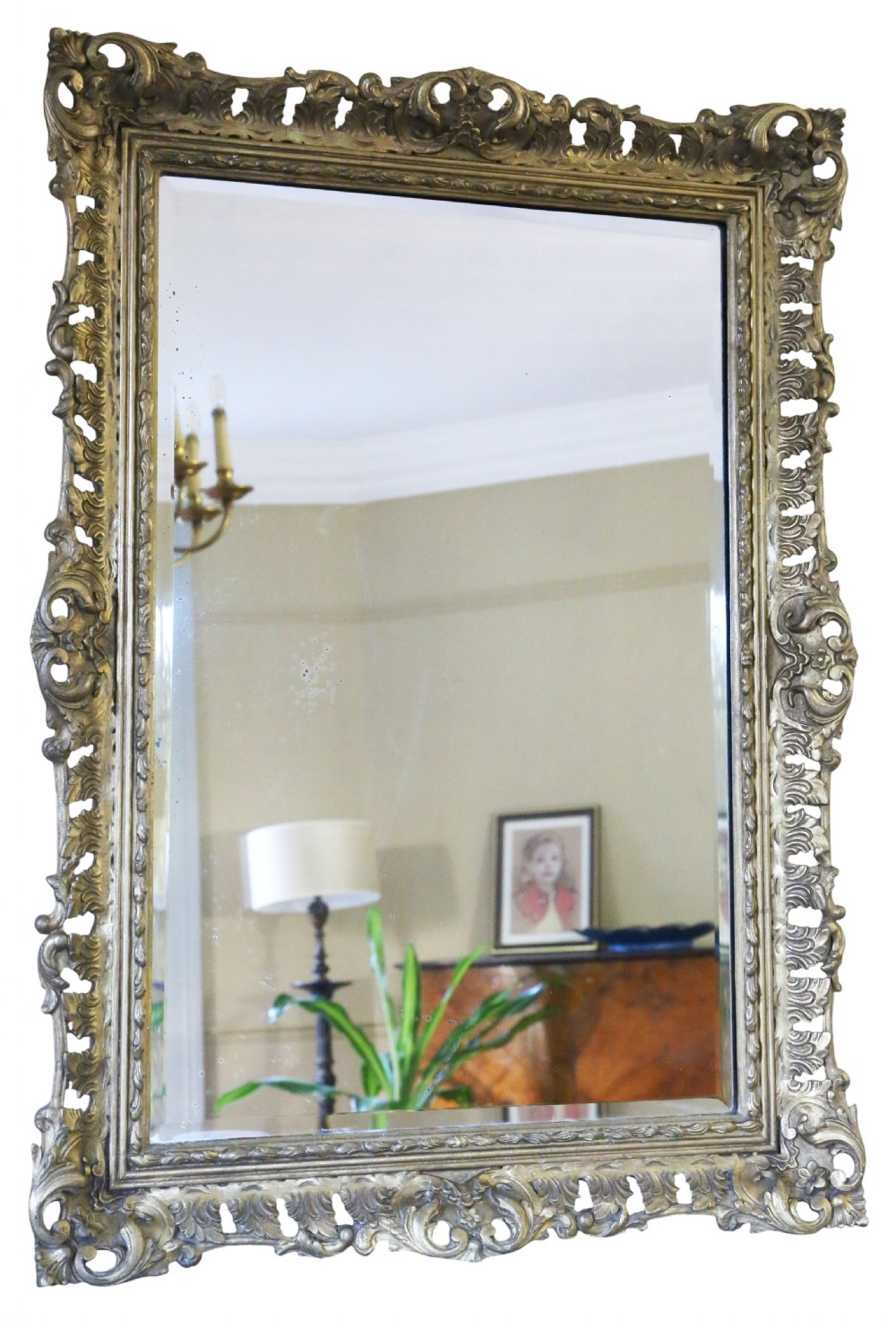 A rectangular 19th-century giltwood mirror featuring an ornate, openwork pierced frame carved with Rococo scrollwork and foliate details.