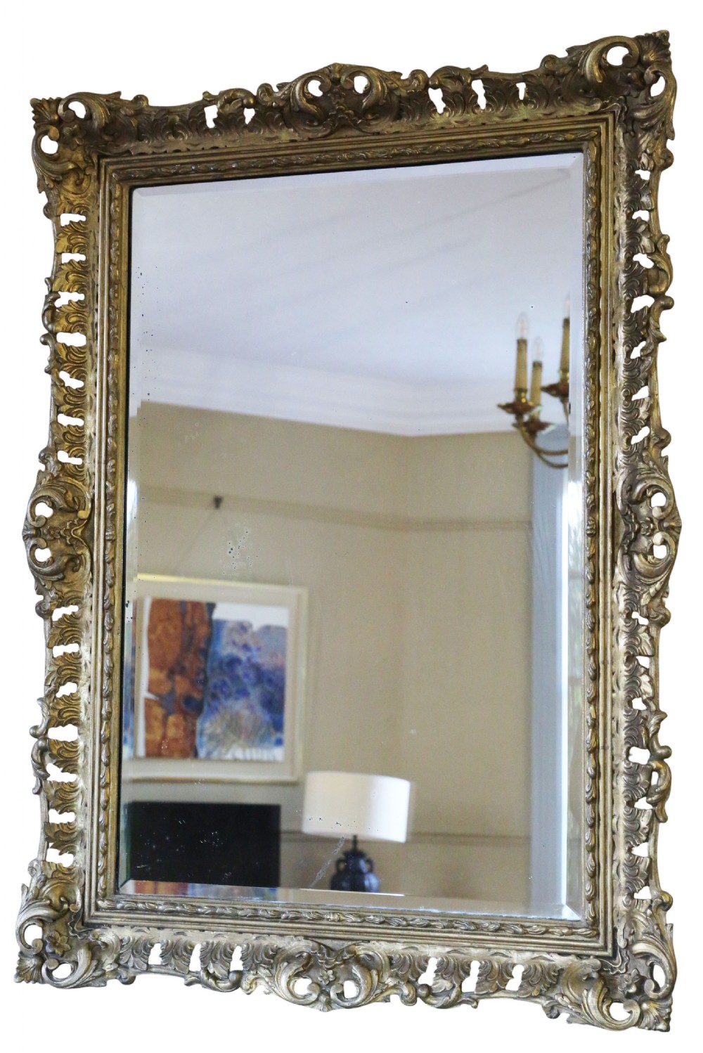 A rectangular 19th-century giltwood mirror featuring an ornate, openwork pierced frame carved with Rococo scrollwork and foliate details. View II