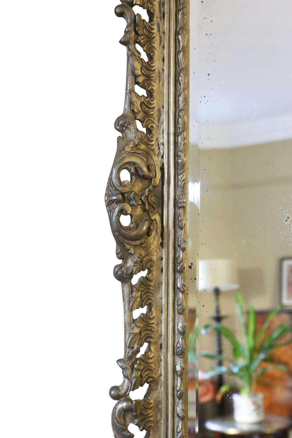 A rectangular 19th-century giltwood mirror featuring an ornate, openwork pierced frame carved with Rococo scrollwork and foliate details. View VI