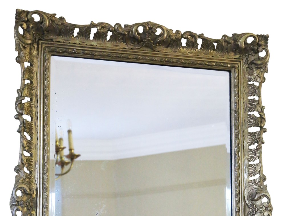A rectangular 19th-century giltwood mirror featuring an ornate, openwork pierced frame carved with Rococo scrollwork and foliate details. View VII
