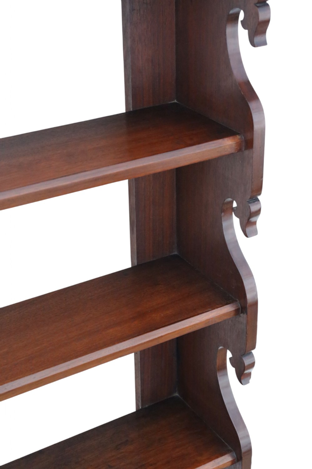A nineteenth-century mahogany hanging wall shelf unit featuring five tiers and decorative carved scroll sides. View VI