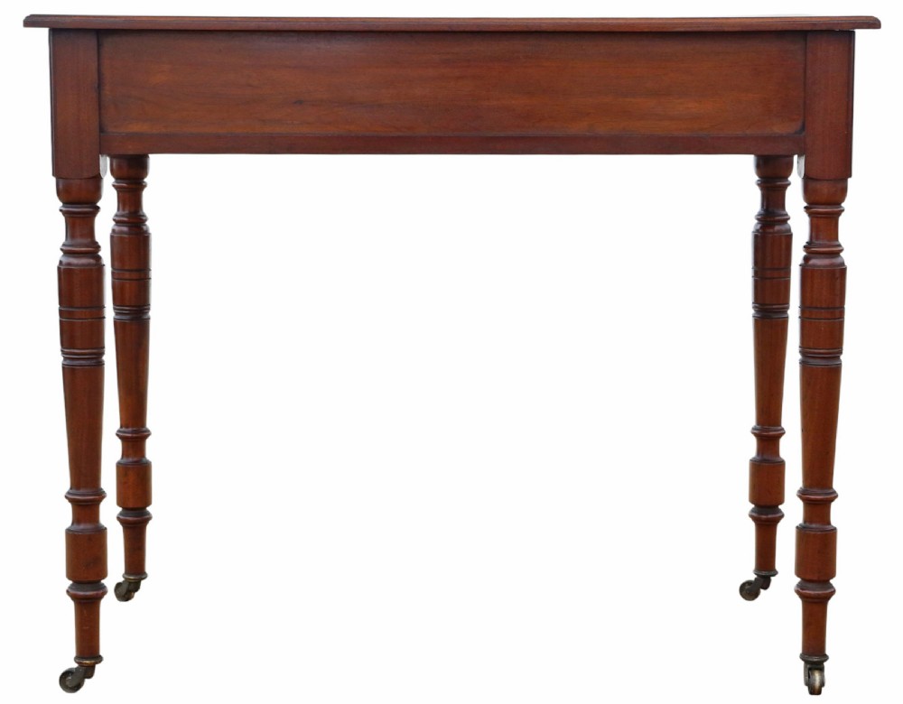 A nineteenth-century burr walnut writing table featuring a figured veneer top, two frieze drawers with turned wooden knobs, and tapering turned legs on brass castors. View VII