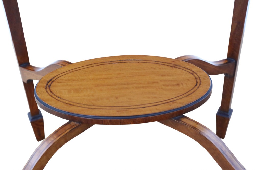 An oval Edwardian satin walnut occasional table with marquetry inlay on the top, slender tapered legs, and an oval undertier. View VII