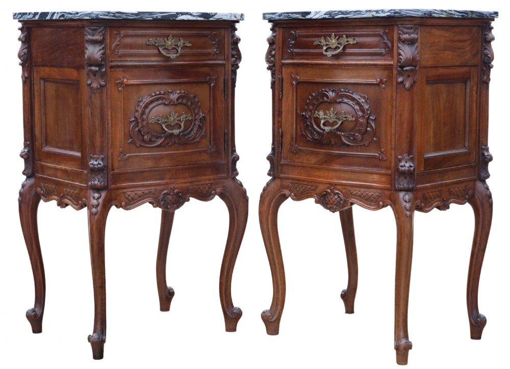A pair of carved walnut bedside tables with dark grey patterned marble tops, single drawers, cupboard doors, and cabriole legs.