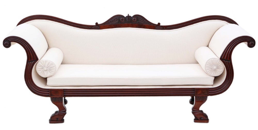 A 19th-century mahogany scroll arm sofa upholstered in neutral cream fabric with two matching bolster cushions and carved timber details. View II