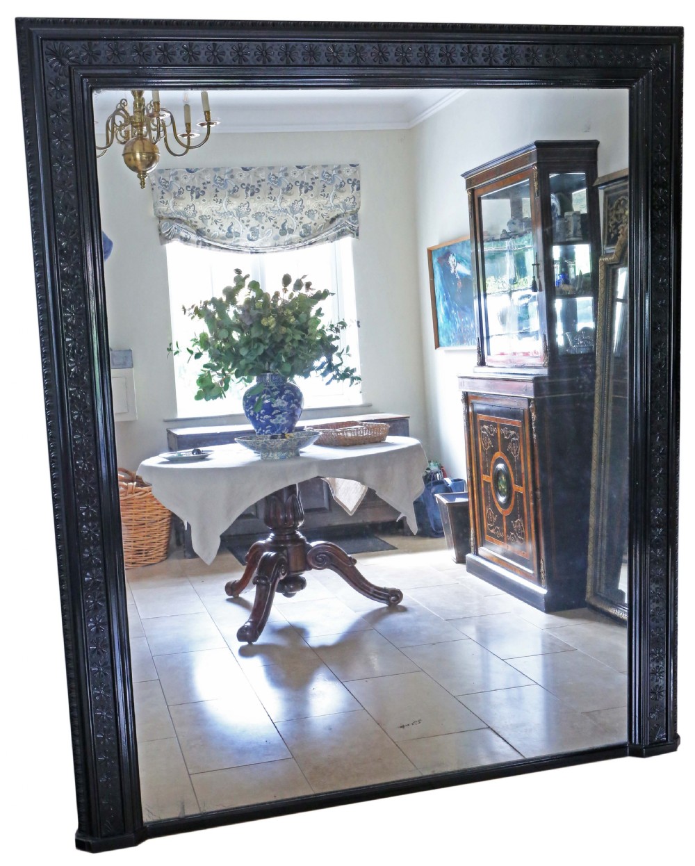 A large, late 19th-century rectangular floor mirror with a wide, ebonised wooden frame decorated with carved rosette mouldings.
