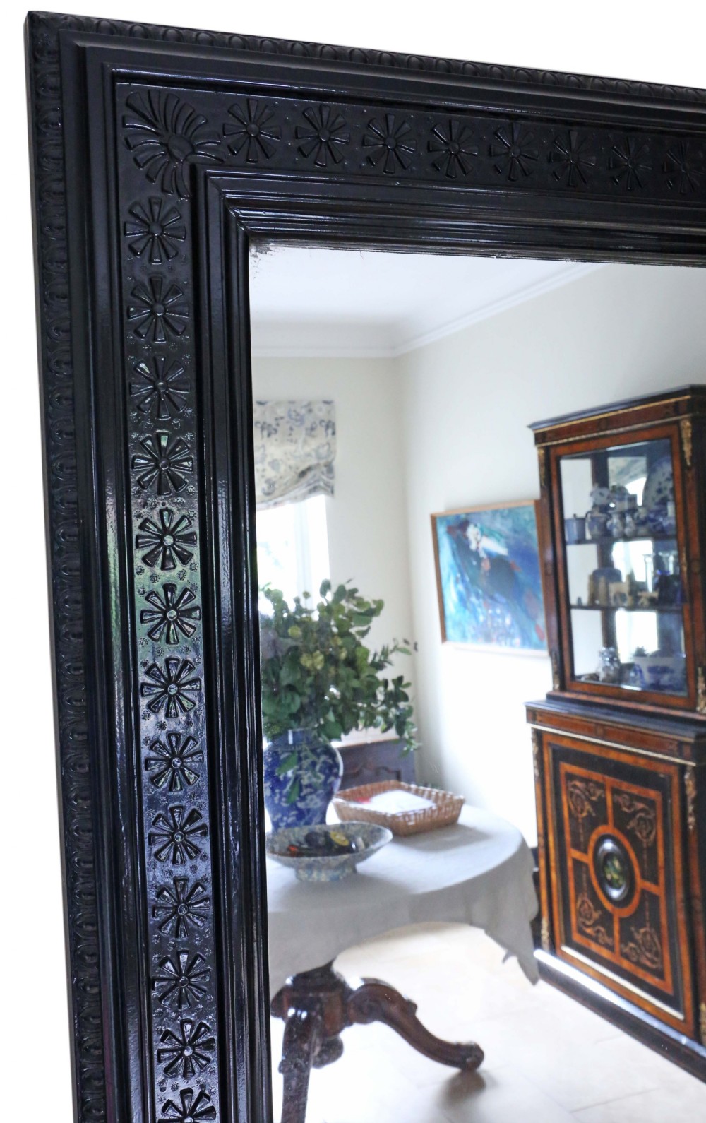 A large, late 19th-century rectangular floor mirror with a wide, ebonised wooden frame decorated with carved rosette mouldings. View V