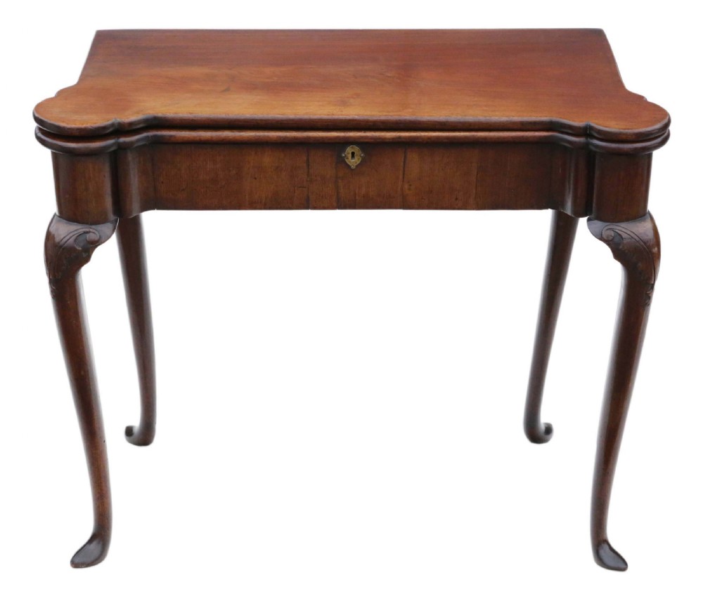 A George II mahogany folding tea table featuring a shaped fold-over top, a single drawer with a brass keyhole escutcheon, and carved cabriole legs ending in pad feet.