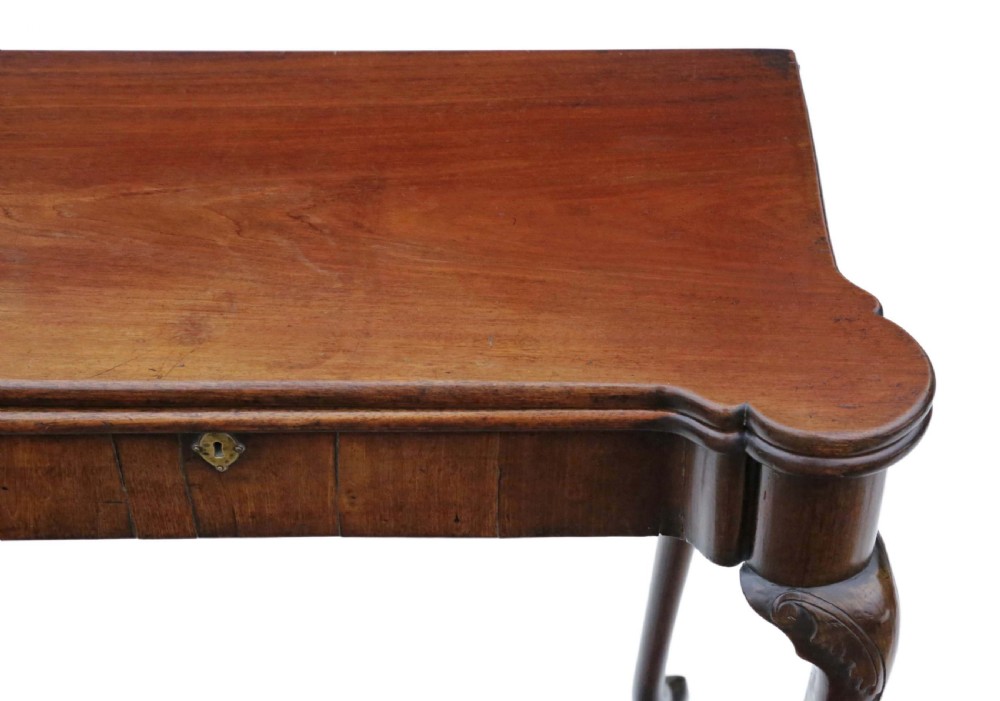 A George II mahogany folding tea table featuring a shaped fold-over top, a single drawer with a brass keyhole escutcheon, and carved cabriole legs ending in pad feet. View IV