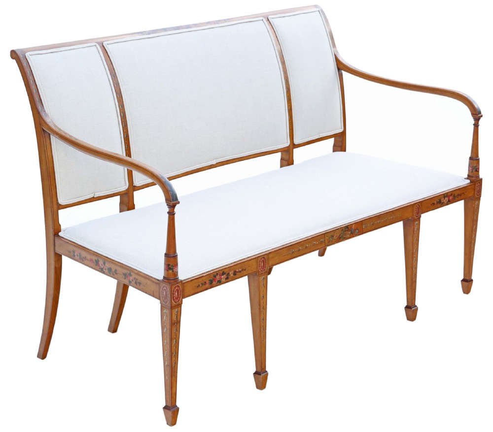 A late 19th-century painted satinwood sofa featuring cream fabric upholstery, three backrest panels, curved armrests, and hand-painted floral detailing on the timber frame. View III
