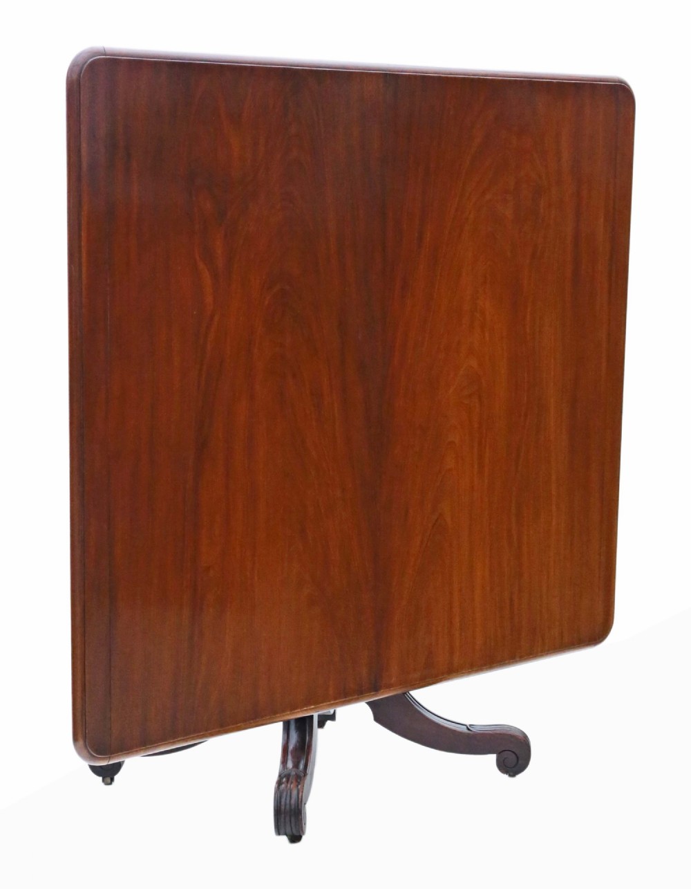 A 19th-century Regency Cuban mahogany dining table featuring a rectangular top with rounded corners supported by a central turned pedestal and four reeded splayed legs with brass castors. View III