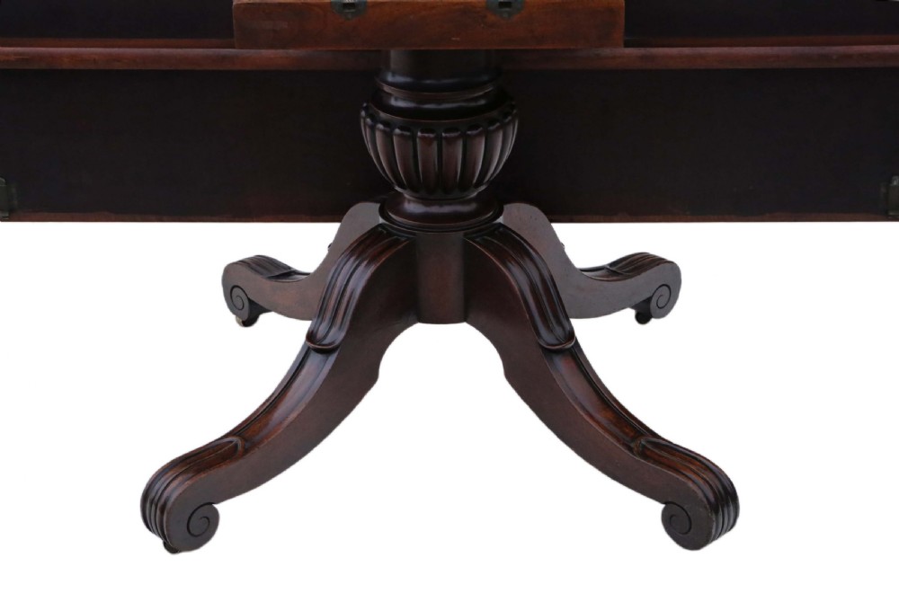 A 19th-century Regency Cuban mahogany dining table featuring a rectangular top with rounded corners supported by a central turned pedestal and four reeded splayed legs with brass castors. View VIII