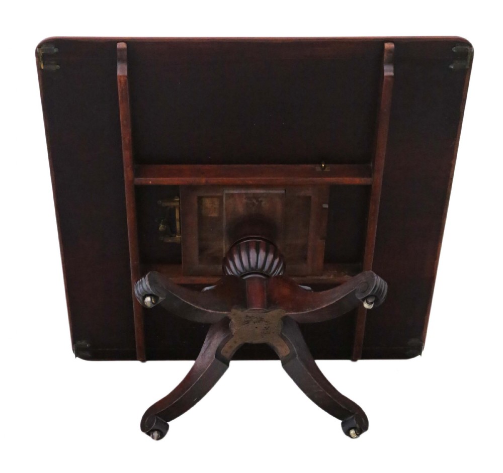 A 19th-century Regency Cuban mahogany dining table featuring a rectangular top with rounded corners supported by a central turned pedestal and four reeded splayed legs with brass castors. View XI
