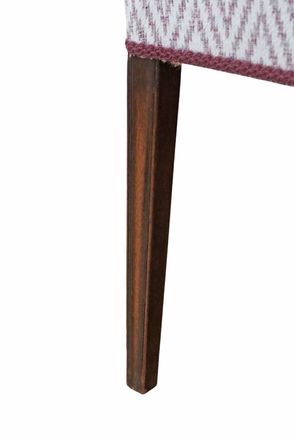 An early 19th-century mahogany elbow chair featuring curved armrests, a carved pierced back splat with rosettes, and light patterned fabric upholstery. View II