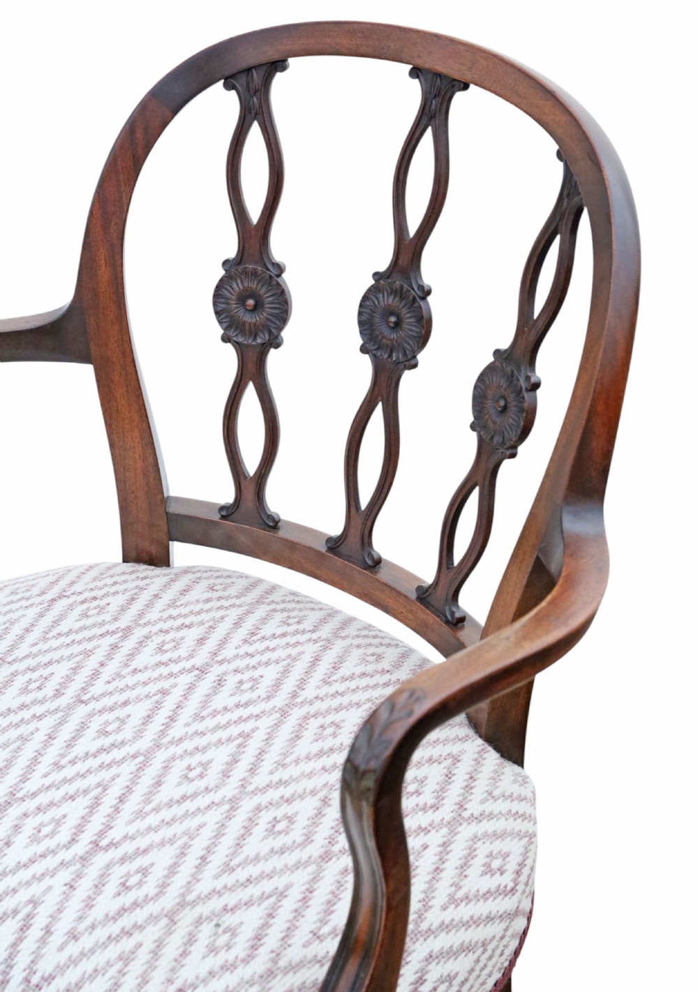 An early 19th-century mahogany elbow chair featuring curved armrests, a carved pierced back splat with rosettes, and light patterned fabric upholstery. View VI