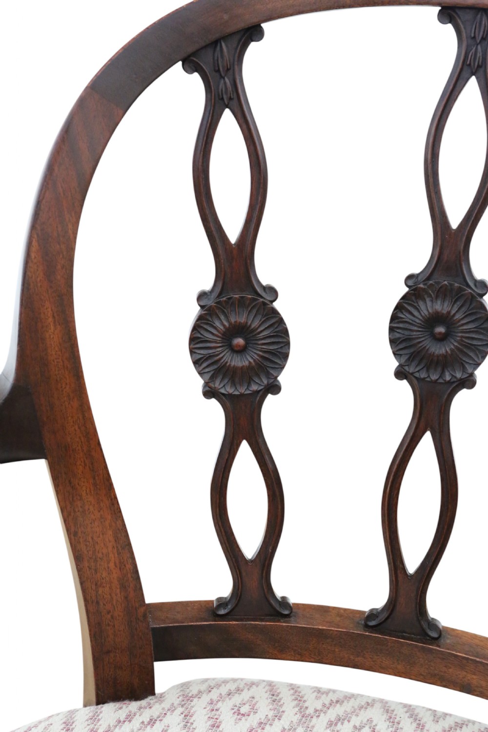 An early 19th-century mahogany elbow chair featuring curved armrests, a carved pierced back splat with rosettes, and light patterned fabric upholstery. View VII