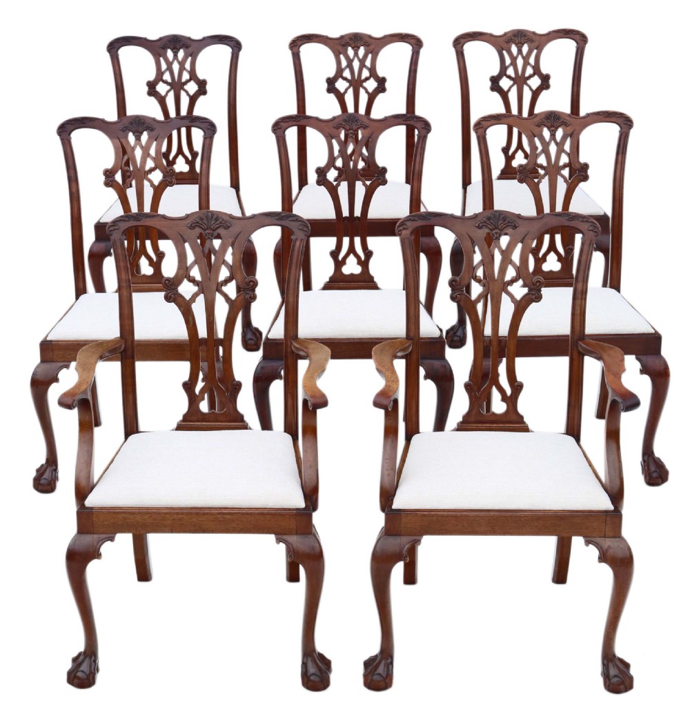 A set of eight Georgian Revival mahogany dining chairs featuring carved pierced splats, cabriole legs with ball-and-claw feet, and white upholstered seats.