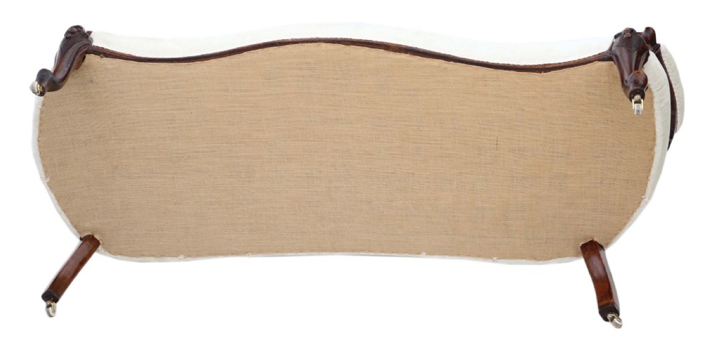A mid-19th century Victorian carved walnut chaise longue with button-backed cream fabric upholstery, pierced floral backrest carving, and cabriole legs on castors. View XI