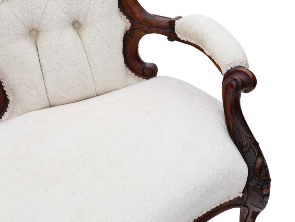A mid-19th century Victorian carved walnut chaise longue with button-backed cream fabric upholstery, pierced floral backrest carving, and cabriole legs on castors. View XII