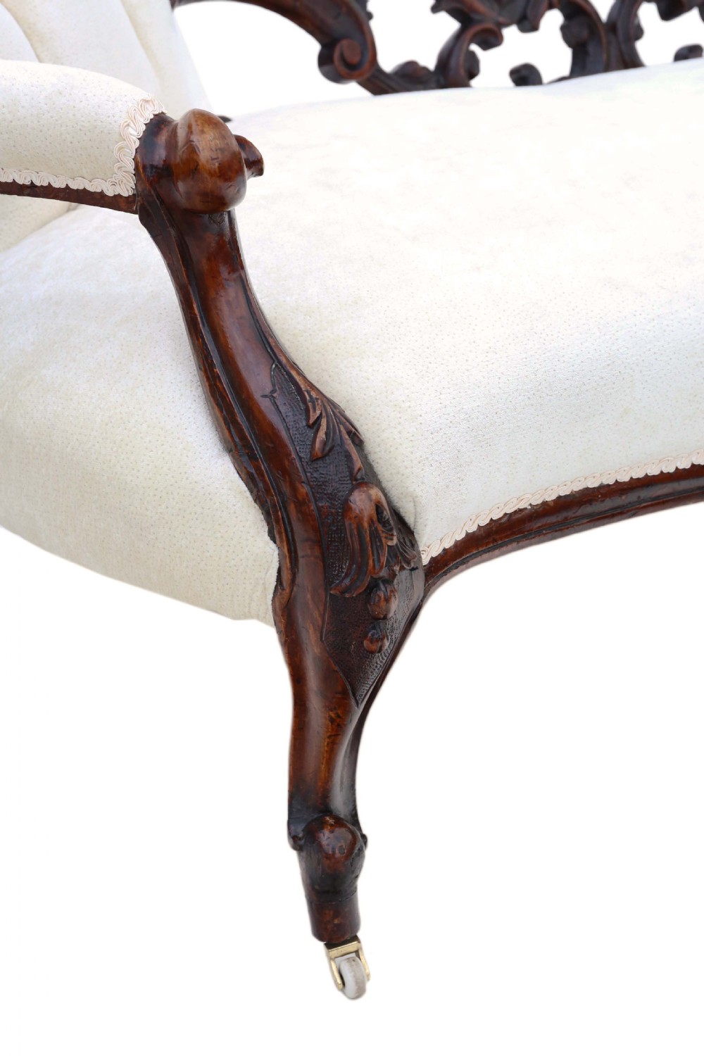 A mid-19th century Victorian carved walnut chaise longue with button-backed cream fabric upholstery, pierced floral backrest carving, and cabriole legs on castors. View XIII