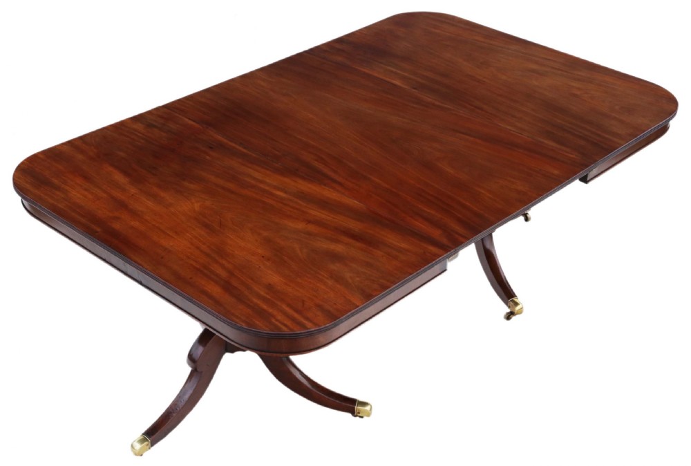 An early 19th century mahogany extending dining table with two pedestal bases, splayed legs, and brass castors. View II