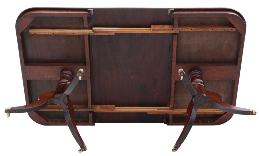 An early 19th century mahogany extending dining table with two pedestal bases, splayed legs, and brass castors. View XVIII