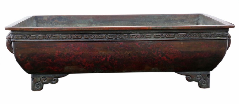 A rectangular dark reddish brown patinated bronze planter with a carved key fret rim border, side handles, and four scroll feet. View II