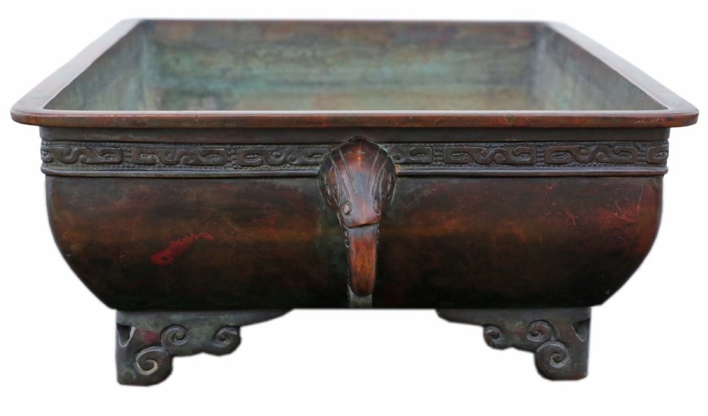 A rectangular dark reddish brown patinated bronze planter with a carved key fret rim border, side handles, and four scroll feet. View IV