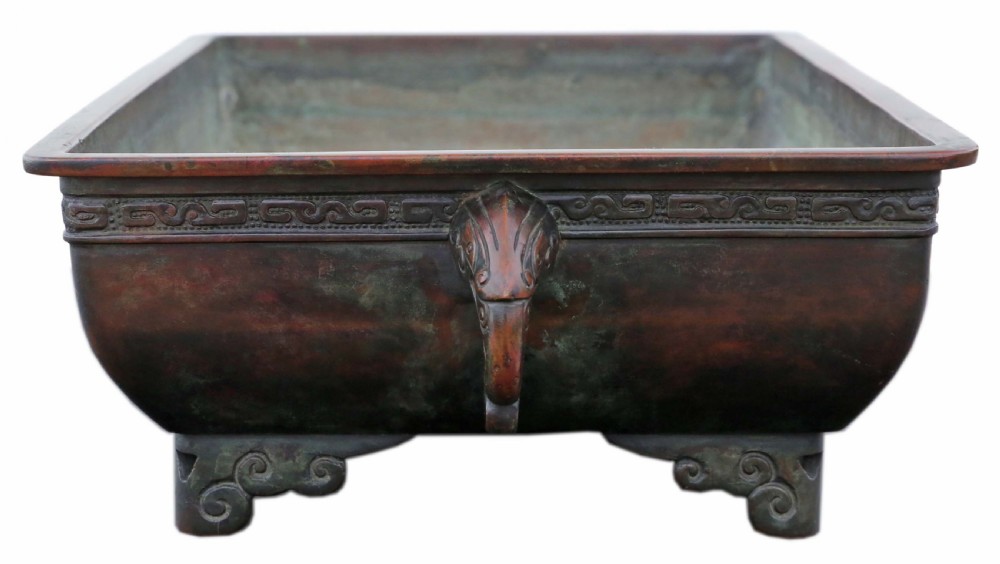 A rectangular dark reddish brown patinated bronze planter with a carved key fret rim border, side handles, and four scroll feet. View V