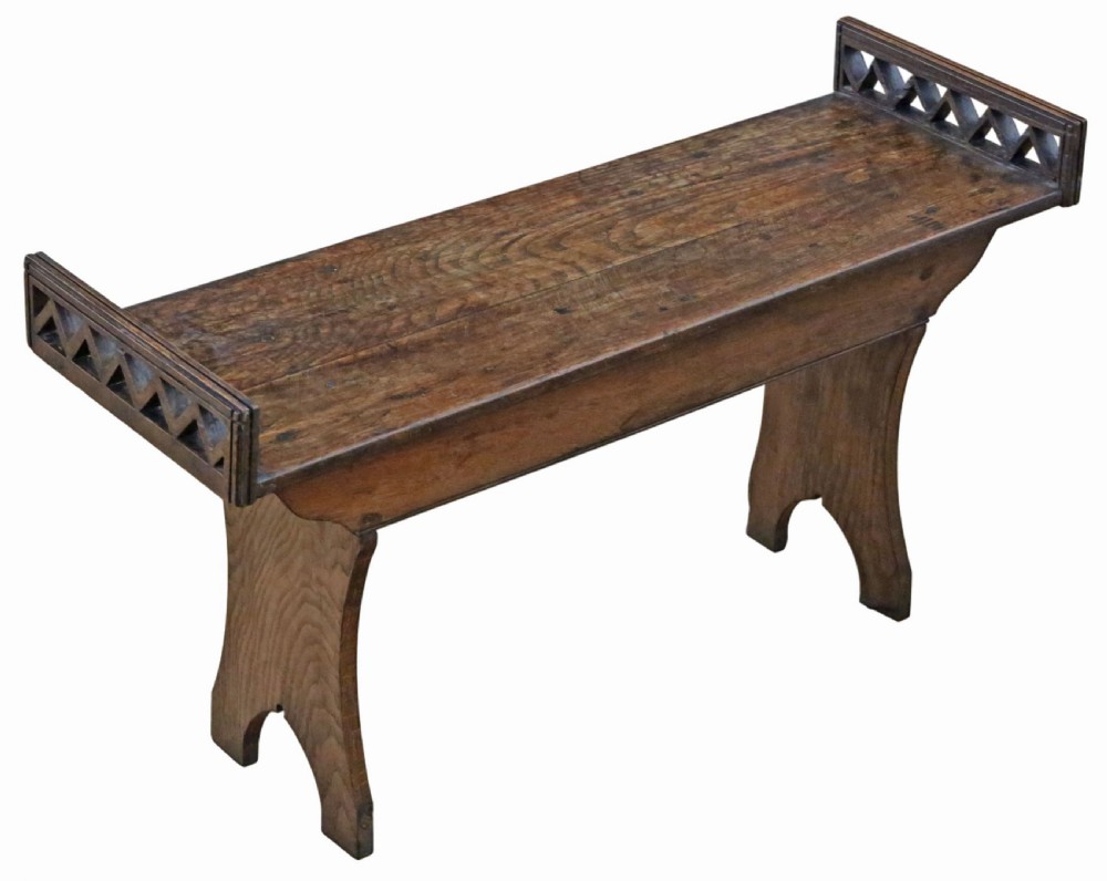 A 19th-century Arts and Crafts oak and elm window seat with pierced geometric gallery ends and solid shaped legs. View II
